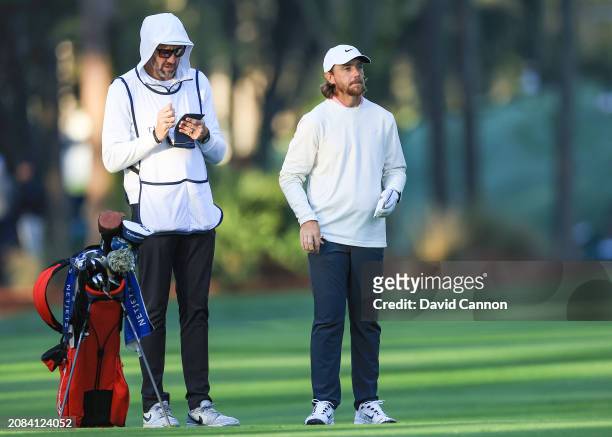 Tommy Fleetwood of England prepares to play his second shot on the 10th hole with his caddie Ian Finnis during the first round of THE PLAYERS...