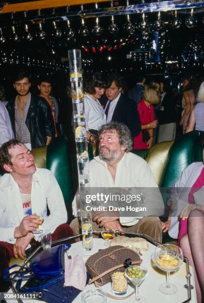 Actor Oliver Reed balancing glasses on top of each other, at his girlfriends 21st birthday party at Stringfellows, London, April 18th 1985.