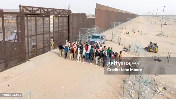 In an aerial view, immigrants wait for transport and processing after crossing the U.S.-Mexico border on March 13, 2024 in El Paso, Texas. The border...