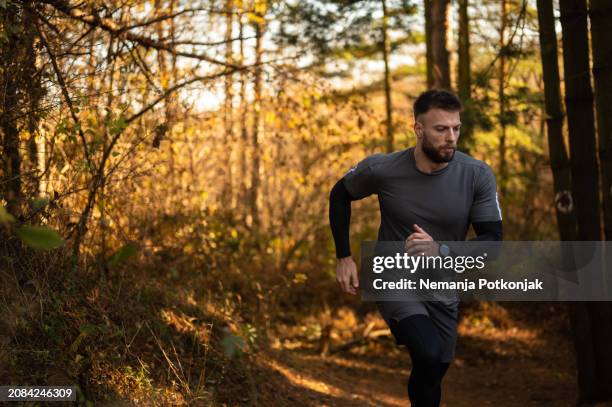 young man running outdoors in the nature - sportsperson stock pictures, royalty-free photos & images