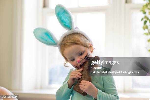 biting a chocolate easter bunny - chocolate face imagens e fotografias de stock