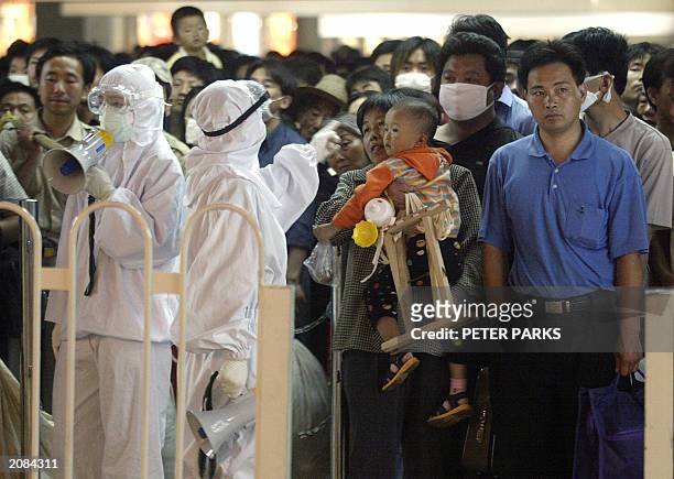 Health inspectors check incoming train passengers for SARS in Beijing railway station 02 June 2003. China reported no new cases of SARS for the first...