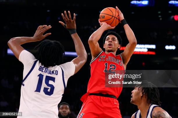 Luis Jr. #12 of the St. John's Red Storm shoots the ball as Jaden Bediako and Dre Davis of the Seton Hall Pirates defend in the first half during the...