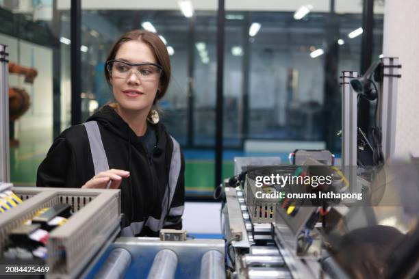 eine junge ingenieurin arbeitet im hauptkontrollraum einer schweißfabrik. sie testet und steuert das panel für den betrieb der hauptanlage. - schaltschrank stock-fotos und bilder