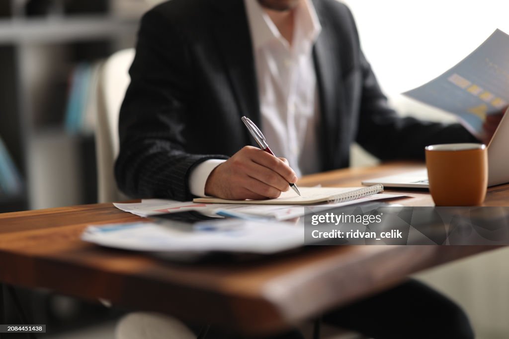 Business accounting concept, Business man using calculator with computer laptop, budget and loan paper in office.