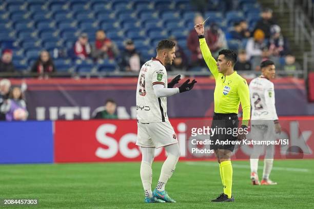 Referee Adonai Escobedo shows the yellow card to Jonathan Moya of LD Alajuelense during a Concacaf Champions Cup: Round of 16 between LD Alajuelense...