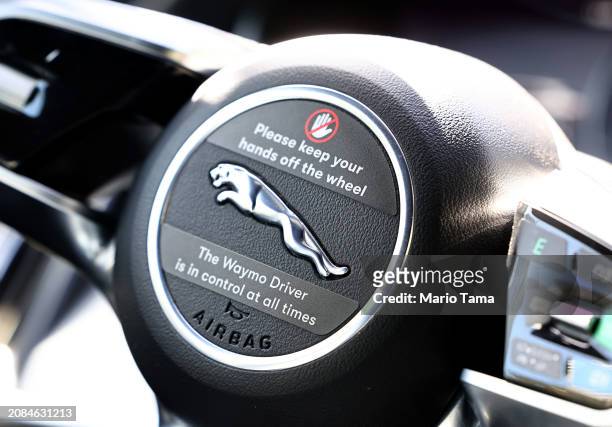 Message reads 'Please keep your hands off the wheel' on the steering wheel of a Waymo autonomous self-driving Jaguar taxi on March 14, 2024 in Los...