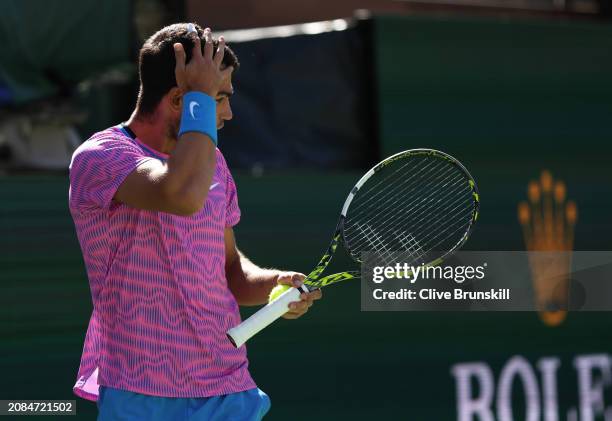 Carlos Alcaraz of Spain is stung by a swam of bees that invaded the court whilst playing against Alexander Zverev of Germany in their Quarterfinal...