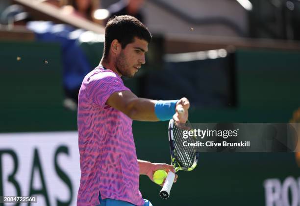 Carlos Alcaraz of Spain tries to brush off a swam of bees that invaded the court whilst playing against Alexander Zverev of Germany in their...