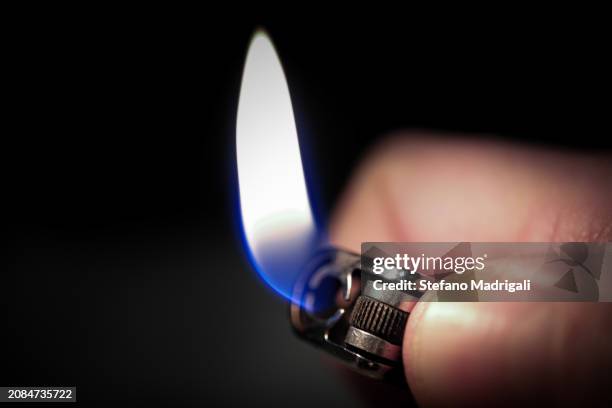 lighter flame in the dark - cigarette lighter stock pictures, royalty-free photos & images