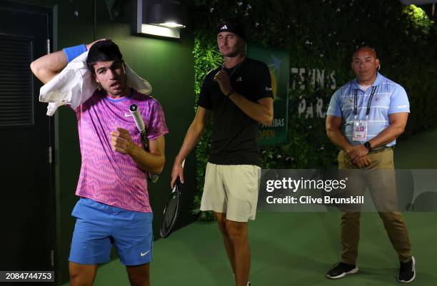 Carlos Alcaraz of Spain and Alexander Zverev of Germany watch on a TV monitor in the players tunnel after running in for cover from a swarm of bees...