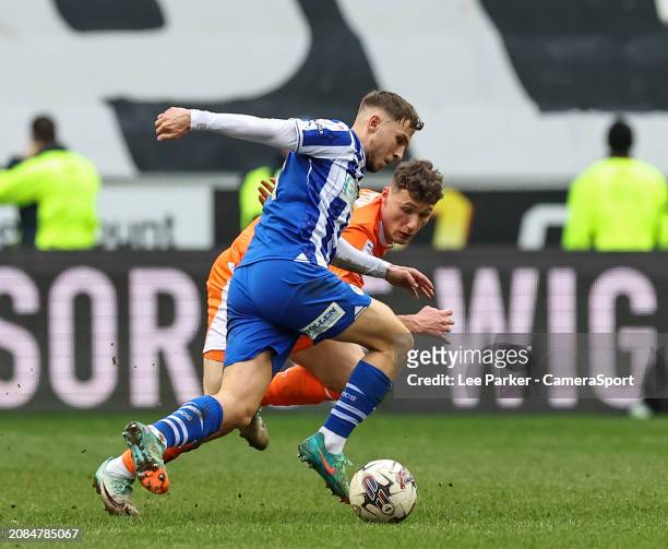 Wigan Athletic's Scott Smith runs with the ball under pressure from Blackpool's Matty Virtue during the Sky Bet League One match between Wigan...