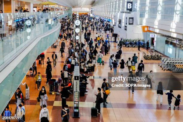 Passengers are seen at the Tokyo International Airport, known as Haneda Airport. The total number of passengers on domestic and international flights...