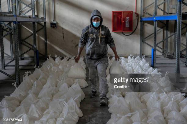 Worker sorts flour bags during the distribution of humanitarian aid in Gaza City on March 17 amid ongoing battles between Israel and the militant...
