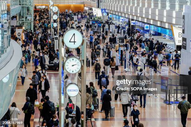 Passengers are seen at the Tokyo International Airport, known as Haneda Airport. The total number of passengers on domestic and international flights...