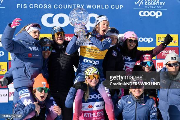 Overall season winner USA's Jessie Diggins celebrates with her team after the last event of the season in FIS Cross Country skiing World Cup in...