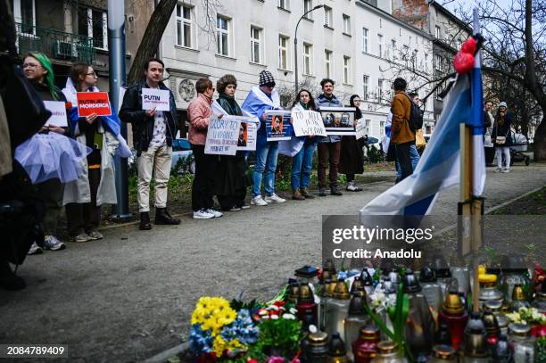 Russian citizens line up to cast their vote as others hold banners and dress as ballet dancers on Russia's election day in front of the Russian...