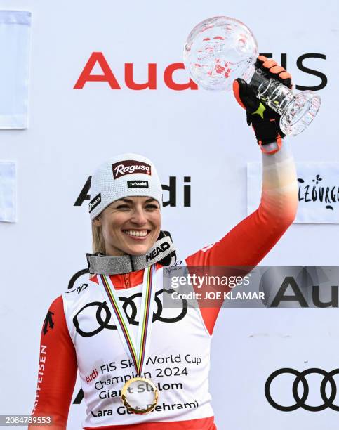 Giant slalom overall winner Switzerland's Lara Gut celebrate with the trophy after the women's Giant Slalom event of FIS Ski Alpine World Cup in...