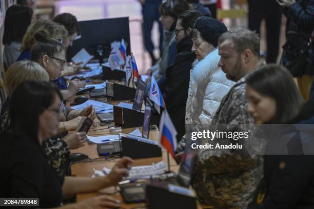 Citizens cast their votes at a polling station during the Russian presidential election in Moscow, Russia on March 17, 2024. The voting process for...
