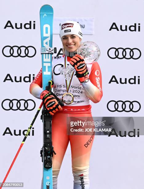 Giant slalom overall winner Switzerland's Lara Gut celebrate with the trophy after the women's Giant Slalom event of FIS Ski Alpine World Cup in...