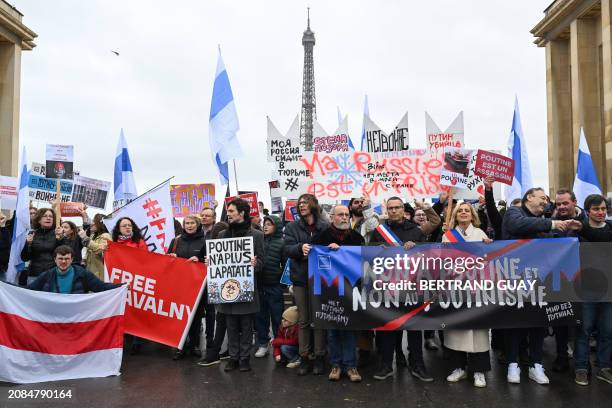 Protesters hold a banner reading "No to Putin, no to Putinism" during a gathering of Navalny's supporters at the Parvis des Droits de l'Homme, with...