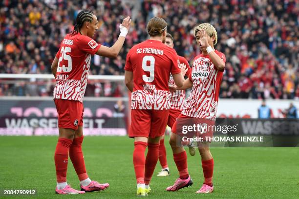 Freiburg's Japanese forward Ritsu Doan celebrates scoring the 1-1 goal with his team-mates during the German first division Bundesliga football match...