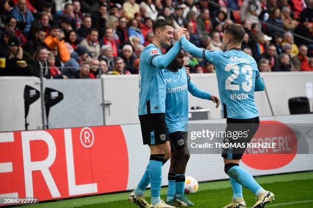 Bayer Leverkusen's Czech forward Patrik Schick is celebrated by team mates after scoring the 1-3 goal during the German first division Bundesliga...