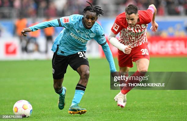 Bayer Leverkusen's Dutch defender Jeremie Frimpong andFreiburg's German defender Christian Guenter vie for the ball during the German first division...