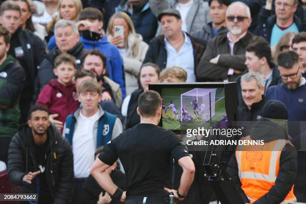 Australian referee Jarred Gillett checks on VAR the second goal scored by West Ham United's English midfielder Michail Antonio and will disallow it...