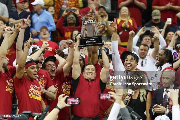 Iowa State Cyclones head coach T.J. Otzelberger lifts the trophy over his head after winning the Big 12 tournament final against the Houston Cougars...