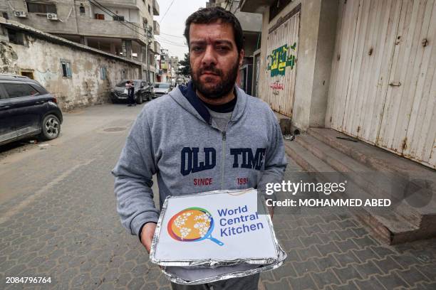 Man carries food aid packages provided by the non-profit non-governmental organisation World Central Kitchen, in Rafah in the southern Gaza Strip on...