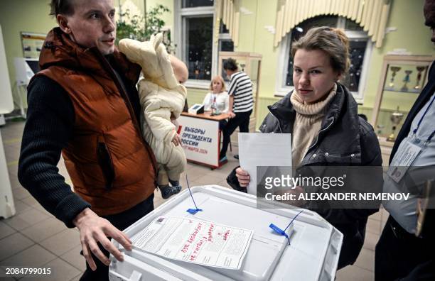 Man casts a spoiled ballot during Russia's presidential election at a polling station in Moscow on March 17, 2024. Russian opposition has called on...
