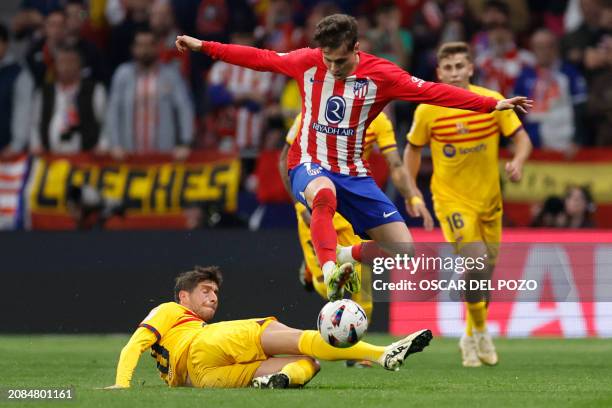 Barcelona's Spanish midfielder Sergi Roberto tackles Atletico Madrid's Spanish midfielder Rodrigo Riquelme during the Spanish league football match...