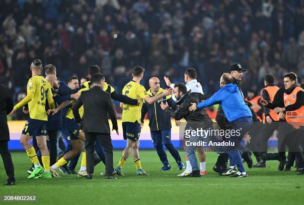 Players of Fenerbahce get in a fight with supporters who jumped on to the field after the Turkish Super Lig week 30 football match between...