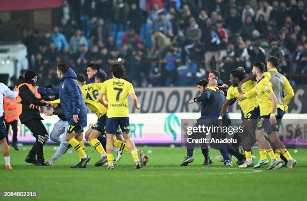 Players of Fenerbahce get in a fight with supporters who jumped on to the field after the Turkish Super Lig week 30 football match between...