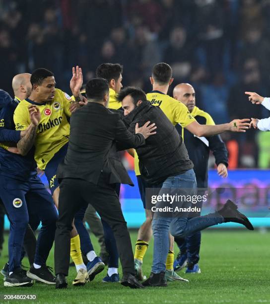 Players of Fenerbahce get in a fight with supporters who jumped on to the field after the Turkish Super Lig week 30 football match between...