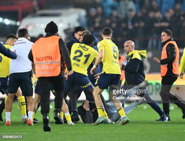 Players of Fenerbahce get in a fight with supporters who jumped on to the field after the Turkish Super Lig week 30 football match between...