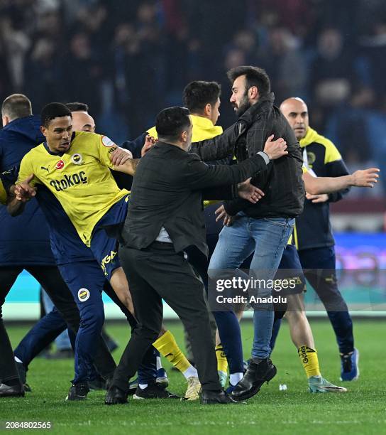 Players of Fenerbahce get in a fight with supporters who jumped on to the field after the Turkish Super Lig week 30 football match between...