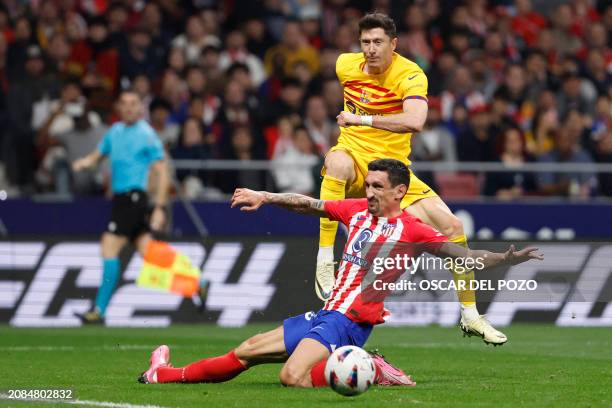 Barcelona's Polish forward Robert Lewandowski vies with Atletico Madrid's Montenegrin defender Stefan Savic during the Spanish league football match...