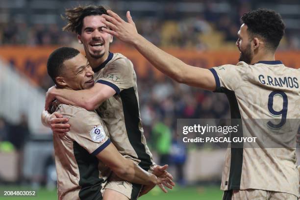 Paris Saint-Germain's French forward Kylian Mbappe embraces Paris Saint-Germain's Portuguese midfielder Vitinha as he celebrates after scoring his...