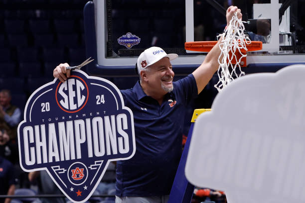 Auburn Tigers head coach Bruce Pearl holds up the net and "champions' sign after winning the championship game of the men's Southeastern Conference...