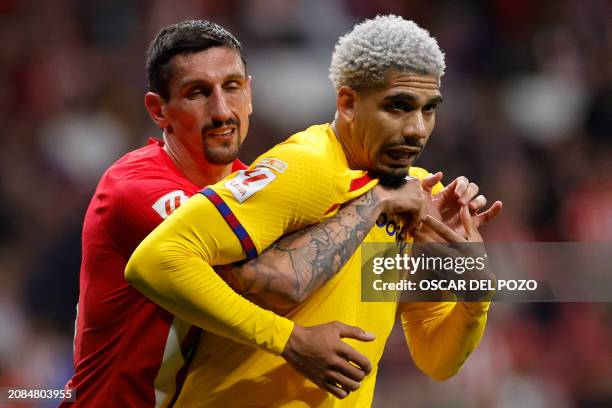 Atletico Madrid's Montenegrin defender Stefan Savic holds Barcelona's Uruguayan defender Ronald Araujo during the Spanish league football match...