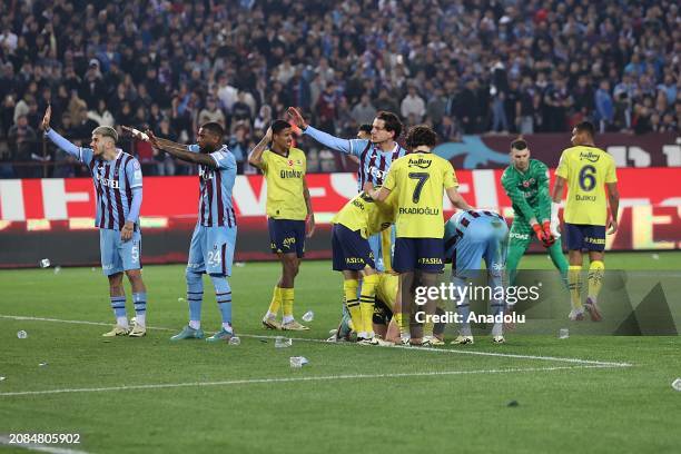 Players of Fenerbahce try to protect themselves from objects, threw on the pitch, during the Turkish Super Lig week 30 football match between...