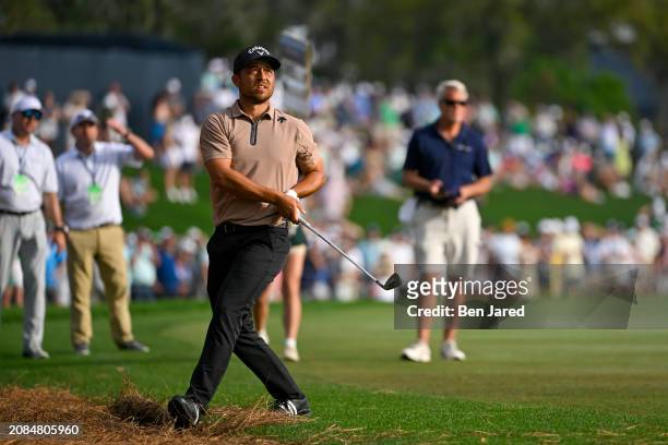 Xander Schauffele reacts to his approach from the pine straw on the 18th hole during the final round of THE PLAYERS Championship at Stadium Course at...
