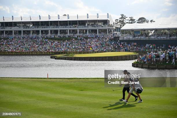 Xander Schauffele and caddie John Ellis walk the 16th fairway during the final round of THE PLAYERS Championship at Stadium Course at TPC Sawgrass on...