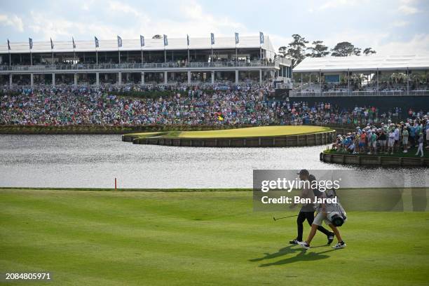 Xander Schauffele and caddie John Ellis walk the 16th fairway during the final round of THE PLAYERS Championship at Stadium Course at TPC Sawgrass on...