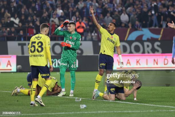 Players of Fenerbahce try to protect themselves from objects, threw on the pitch, during the Turkish Super Lig week 30 football match between...