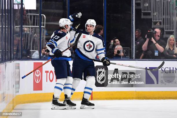 Tyler Toffoli of the Winnipeg Jets celebrates his third period goal with teammate Sean Monahan of the Winnipeg Jets during a game against the...