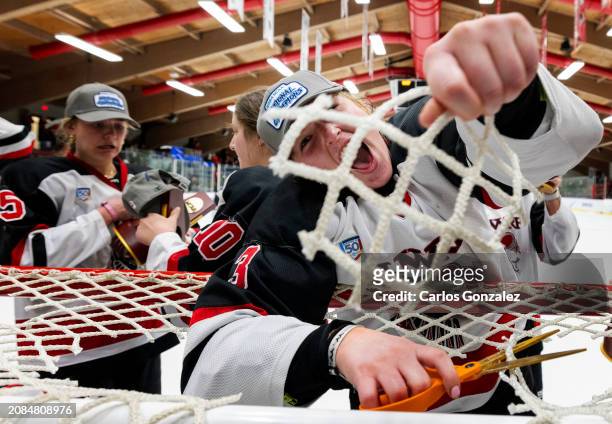 Madison Kadrlik of Wisconsin-River Falls Falcons cuts out netting from the goal after the Division III Women's Ice Hockey Championship held at Hunt...