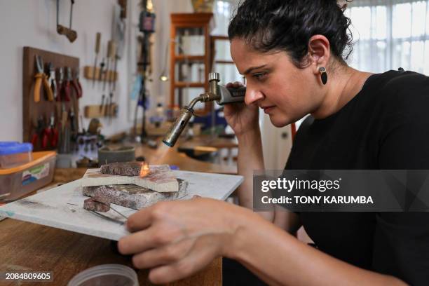Kenyan designer Ami Doshi Shah, crafts jewelry using a blow torch at her home studio, where she creates eclectic hand-made jewelry using locally...